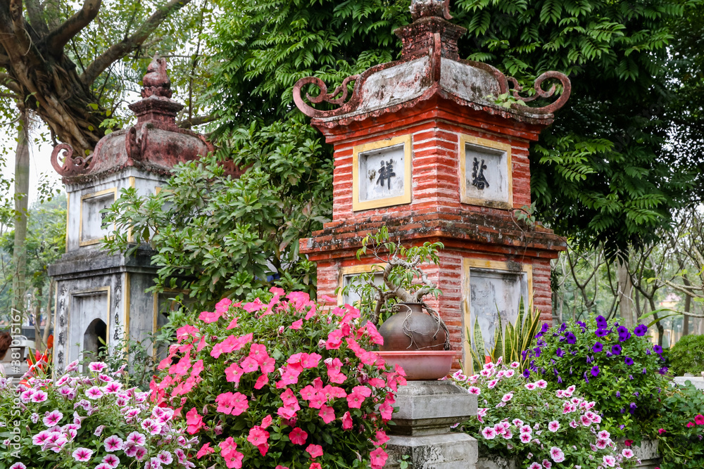Flowers and sculptures at the one pillar pagoda in Hanoi Vietnam
