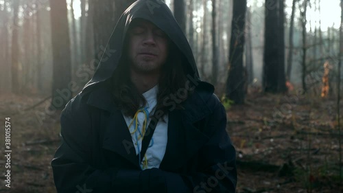 Monk Prayer. Wanderer Pilgrim in Black Cloak with Cowl Praying in Misty Wood. Autumn Morning. 2x Slow motion 60 fps 4K