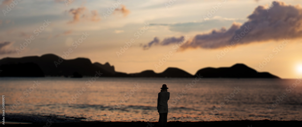 a Lonely girl looking at the horizon over calm ocean sunset time. a Lonely girl looking at the horizon over calm ocean sunset time.
