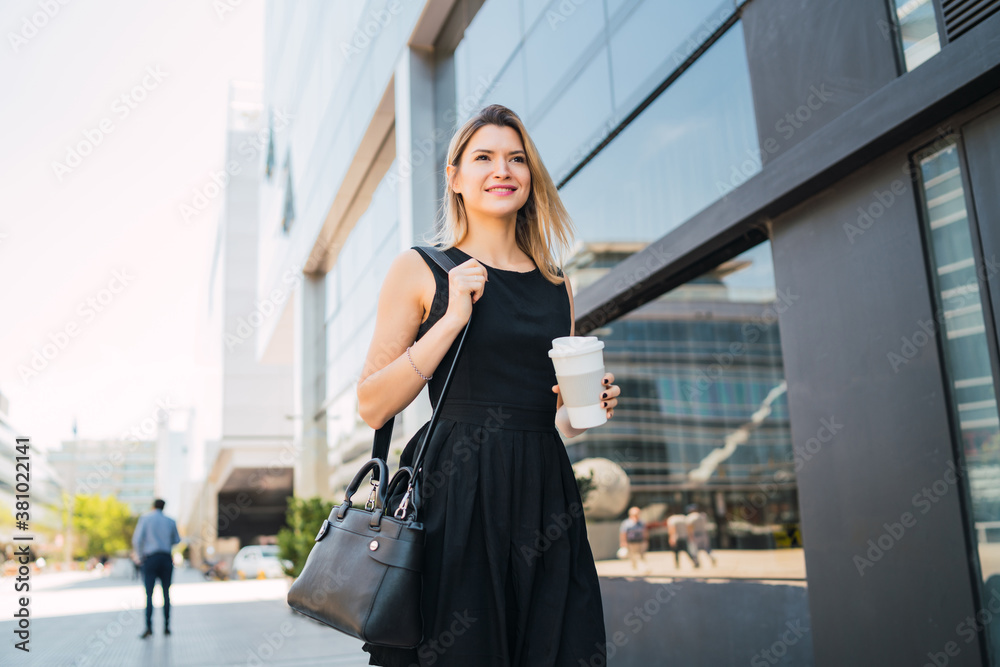 Fototapeta premium Business woman walking to work while drinking coffee.