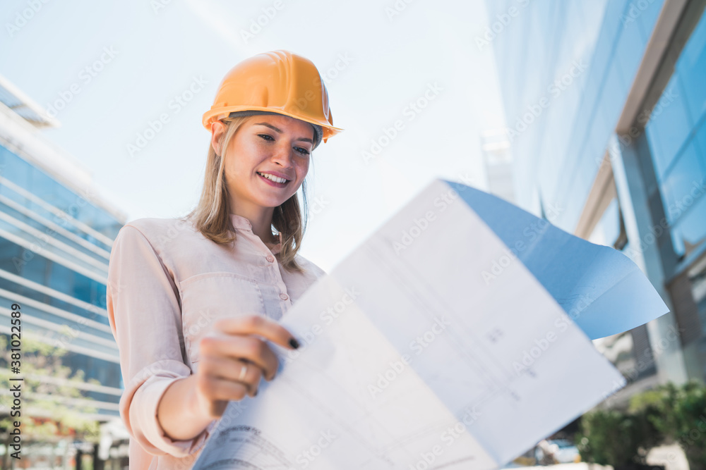 Professional architect holding blueprints outdoors. Professional architect holding blueprints outdoors.