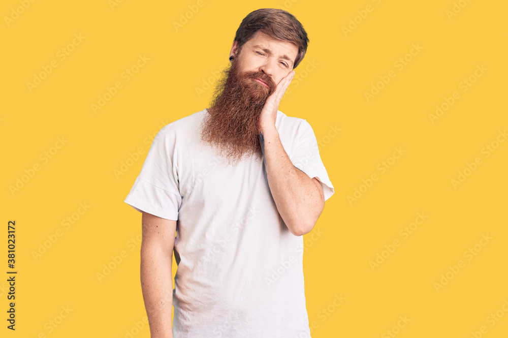Handsome young red head man with long beard wearing casual white tshirt thinking looking tired and bored with depression problems with crossed arms. Handsome young red head man with long beard wearing casual white tshirt thinking looking tired and bored with depression problems with crossed arms.