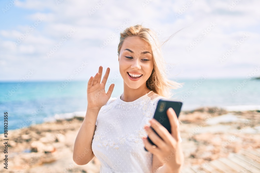 Young caucasian girl smiling happy doing video call using smartphone at street of city.
