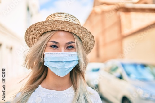Young caucasian tourist girl wearing medical mask walking at street of city. © Krakenimages.com