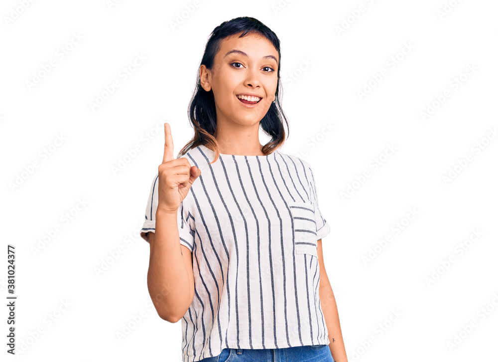 Young woman wearing casual clothes pointing finger up with successful idea. exited and happy. number one. Young woman wearing casual clothes pointing finger up with successful idea. exited and happy. number one.