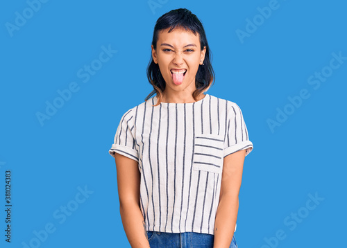 Young woman wearing casual clothes sticking tongue out happy with funny expression. emotion concept.