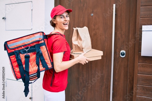 Delivery business worker woman wearing uniform smiling happy knocking on the door photo