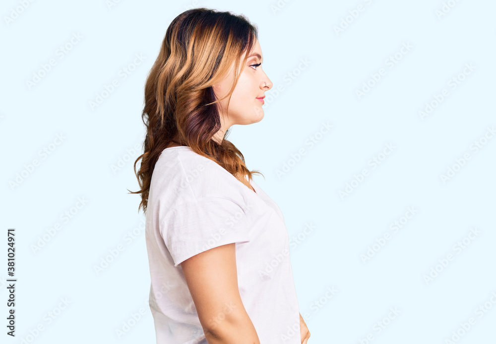 Young beautiful caucasian woman wearing casual white tshirt looking to side, relax profile pose with natural face and confident smile. Young beautiful caucasian woman wearing casual white tshirt looking to side, relax profile pose with natural face and confident smile.