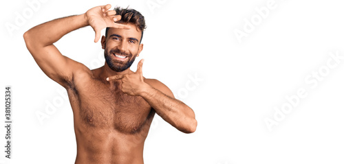 Young hispanic man wearing swimwear shirtless smiling making frame with hands and fingers with happy face. creativity and photography concept.