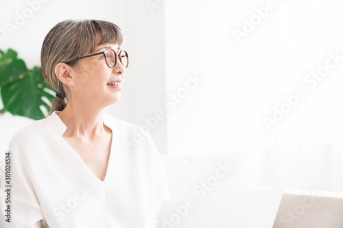 部屋でラップトップコンピューターを見るシニア女性