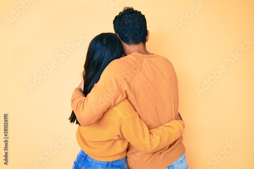 Beautiful latin young couple wearing casual clothes together hugging oneself happy and positive from backwards. self love and self care © Krakenimages.com
