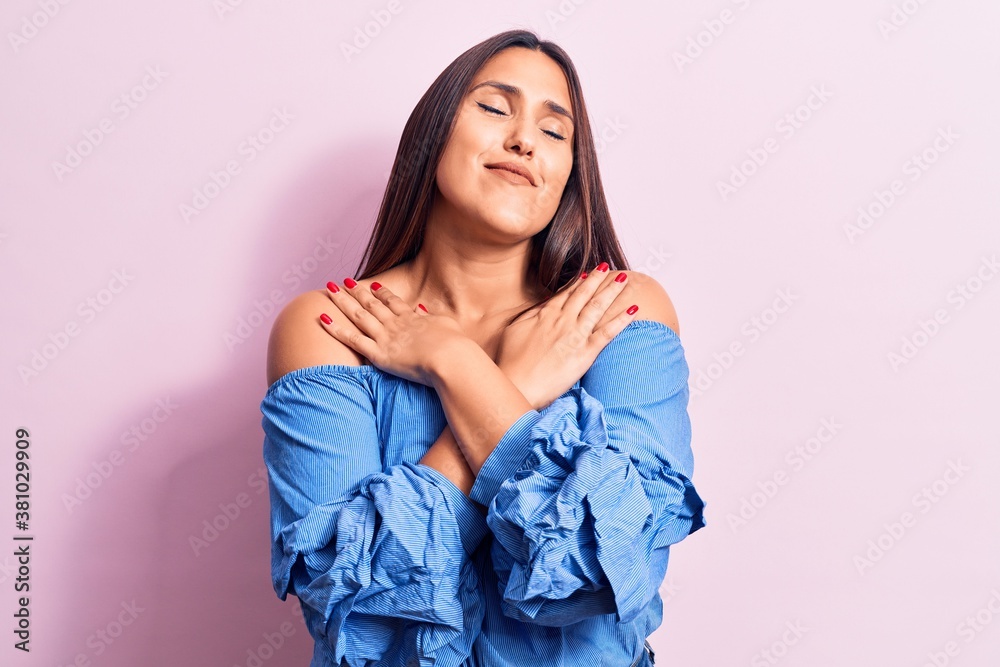Young beautiful brunette woman wearing casual t-shirt hugging oneself happy and positive, smiling confident. self love and self care Young beautiful brunette woman wearing casual t-shirt hugging oneself happy and positive, smiling confident. self love and self care