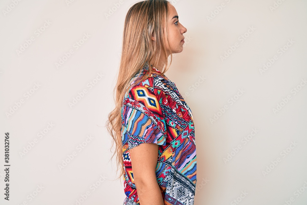 Young beautiful blonde woman wearing modern clothes looking to side, relax profile pose with natural face with confident smile. Young beautiful blonde woman wearing modern clothes looking to side, relax profile pose with natural face with confident smile.