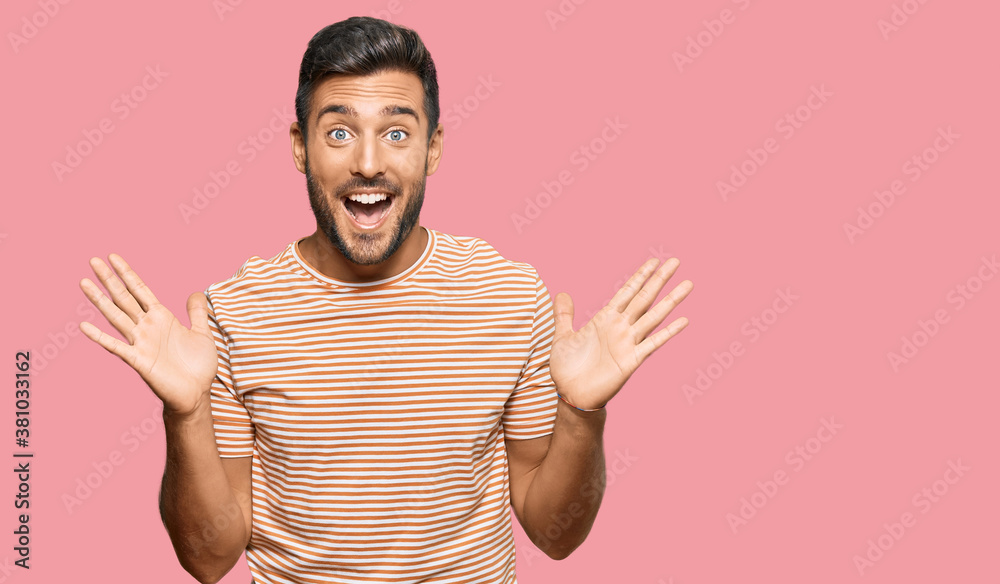 Handsome hispanic man wearing casual clothes celebrating crazy and amazed for success with arms raised and open eyes screaming excited. winner concept Handsome hispanic man wearing casual clothes celebrating crazy and amazed for success with arms raised and open eyes screaming excited. winner concept