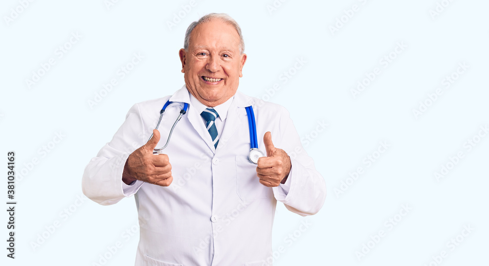 Senior handsome grey-haired man wearing doctor coat and stethoscope success sign doing positive gesture with hand, thumbs up smiling and happy. cheerful expression and winner gesture. Senior handsome grey-haired man wearing doctor coat and stethoscope success sign doing positive gesture with hand, thumbs up smiling and happy. cheerful expression and winner gesture.