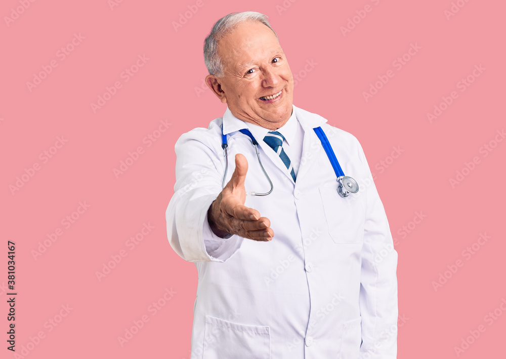 Senior handsome grey-haired man wearing doctor coat and stethoscope smiling cheerful offering palm hand giving assistance and acceptance. Senior handsome grey-haired man wearing doctor coat and stethoscope smiling cheerful offering palm hand giving assistance and acceptance.