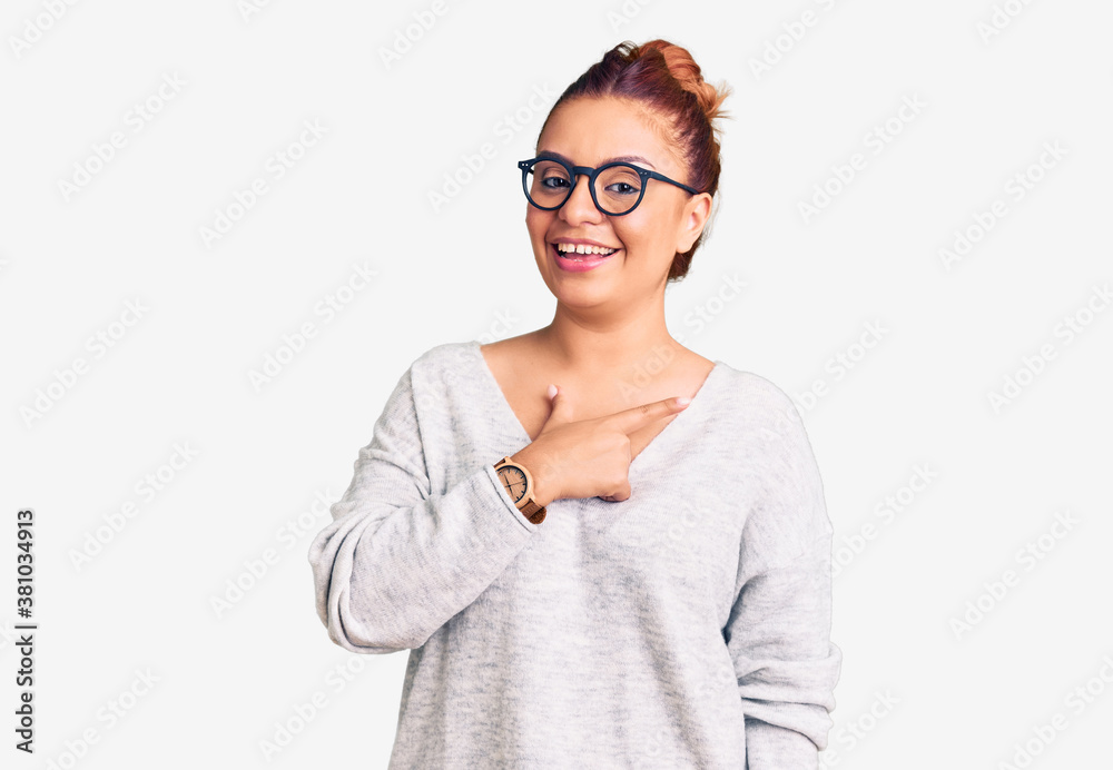 Young latin woman wearing casual clothes cheerful with a smile of face pointing with hand and finger up to the side with happy and natural expression on face Young latin woman wearing casual clothes cheerful with a smile of face pointing with hand and finger up to the side with happy and natural expression on face