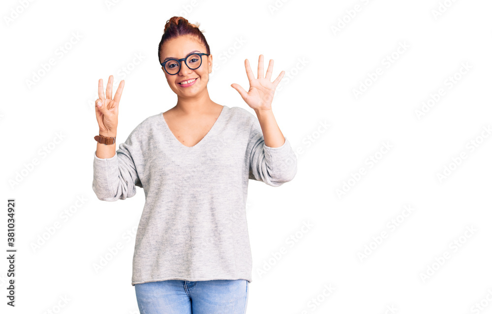 Young latin woman wearing casual clothes showing and pointing up with fingers number eight while smiling confident and happy. Young latin woman wearing casual clothes showing and pointing up with fingers number eight while smiling confident and happy.
