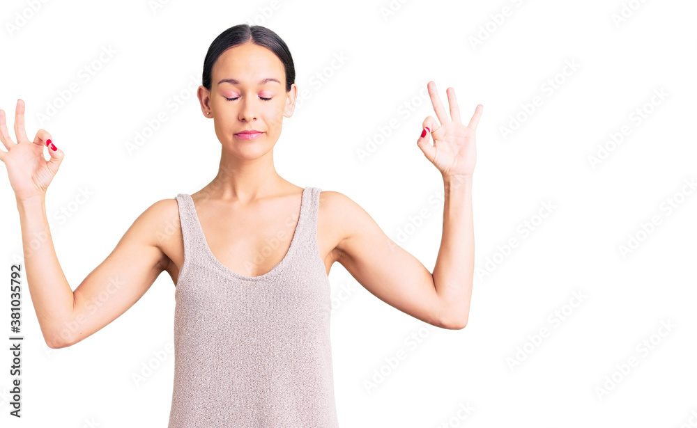 Beautiful brunette young woman wearing casual dress relax and smiling with eyes closed doing meditation gesture with fingers. yoga concept. Beautiful brunette young woman wearing casual dress relax and smiling with eyes closed doing meditation gesture with fingers. yoga concept.