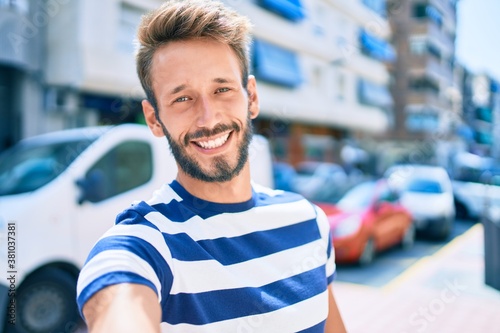 Handsome caucasian man with beard smiling happy taking a selfie picture outdoors © Krakenimages.com