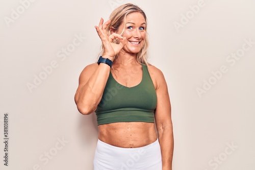 Middle age caucasian blonde woman wearing sportswear smiling positive doing ok sign with hand and fingers. successful expression.