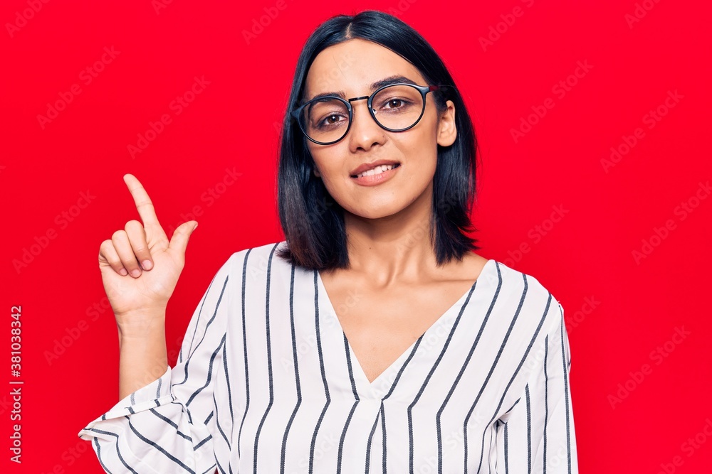 Young beautiful latin woman wearing casual clothes smiling with an idea or question pointing finger up with happy face, number one