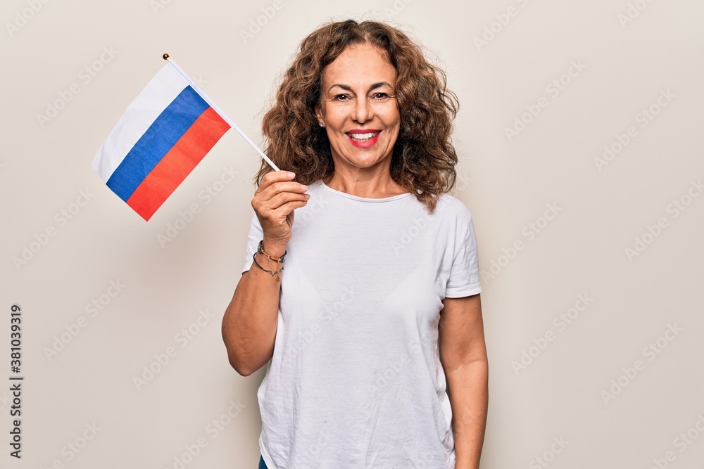 Middle age beautiful tourist woman holding russian flag over isolated white background looking positive and happy standing and smiling with a confident smile showing teeth Middle age beautiful tourist woman holding russian flag over isolated white background looking positive and happy standing and smiling with a confident smile showing teeth