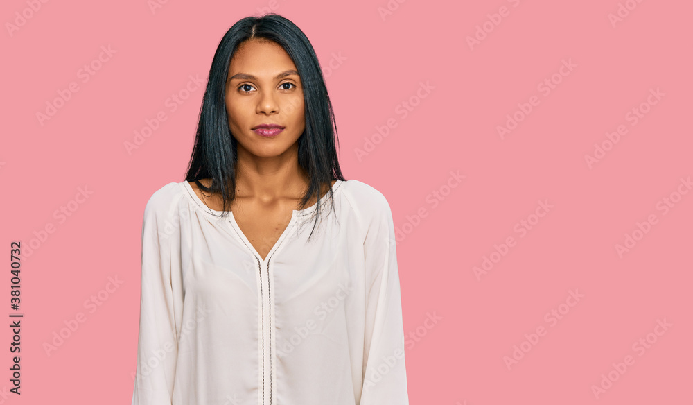 Young african american woman wearing casual clothes with serious expression on face. simple and natural looking at the camera. Young african american woman wearing casual clothes with serious expression on face. simple and natural looking at the camera.