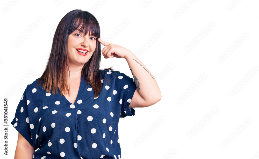 Young plus size woman wearing casual clothes smiling pointing to head with one finger, great idea or thought, good memory Young plus size woman wearing casual clothes smiling pointing to head with one finger, great idea or thought, good memory