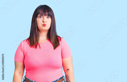 Bild auf Leinwand Young plus size woman wearing casual clothes puffing cheeks with funny face