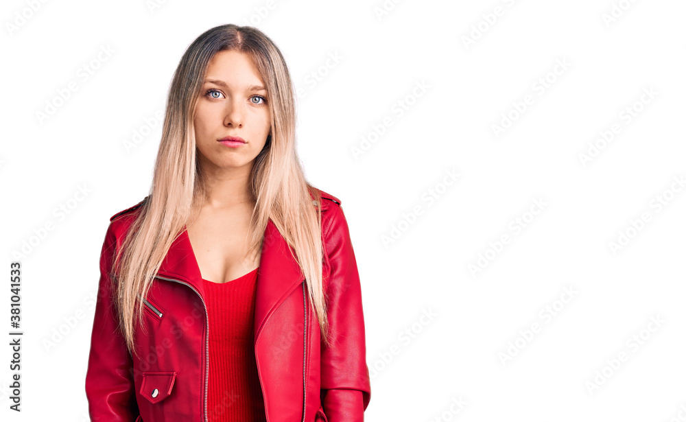 Young beautiful blonde woman wearing red leather jacket with serious expression on face. simple and natural looking at the camera. Young beautiful blonde woman wearing red leather jacket with serious expression on face. simple and natural looking at the camera.