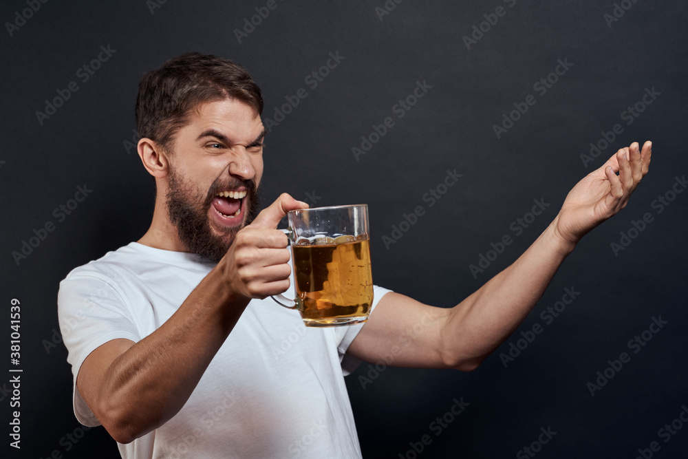 Man with a mug of beer in his hands emotions fun lifestyle white t-shirt dark isolated background