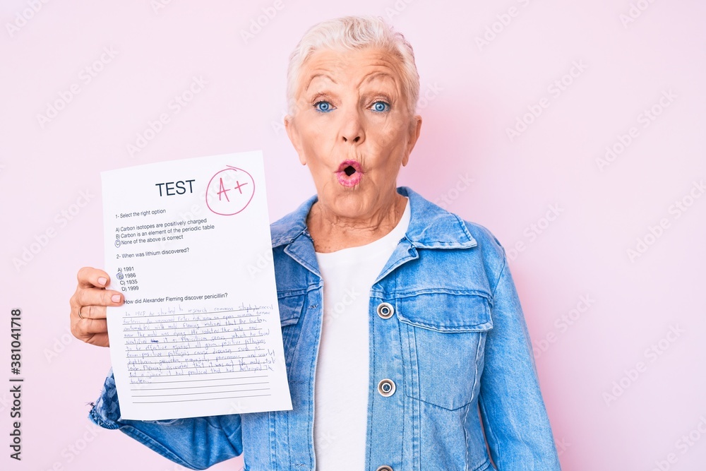 Senior beautiful woman with blue eyes and grey hair showing a passed exam scared and amazed with open mouth for surprise, disbelief face Senior beautiful woman with blue eyes and grey hair showing a passed exam scared and amazed with open mouth for surprise, disbelief face