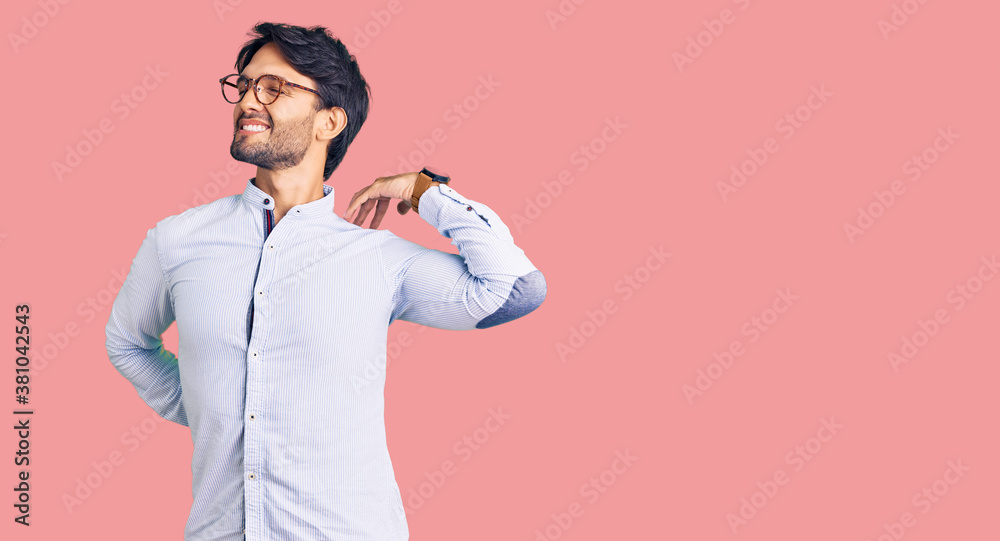 Handsome hispanic man wearing business shirt and glasses suffering of neck ache injury, touching neck with hand, muscular pain Handsome hispanic man wearing business shirt and glasses suffering of neck ache injury, touching neck with hand, muscular pain