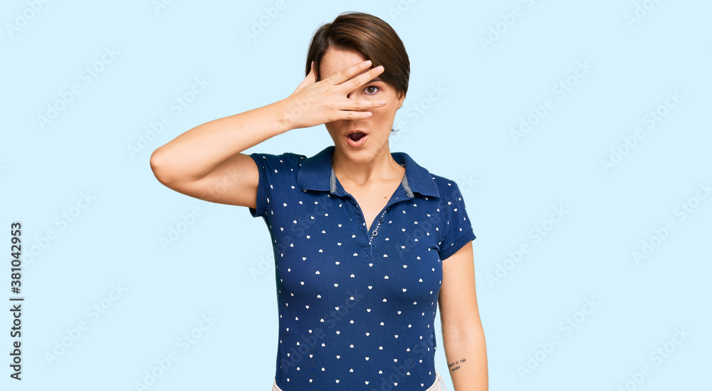 Young brunette woman with short hair wearing casual clothes peeking in shock covering face and eyes with hand, looking through fingers with embarrassed expression. Young brunette woman with short hair wearing casual clothes peeking in shock covering face and eyes with hand, looking through fingers with embarrassed expression.