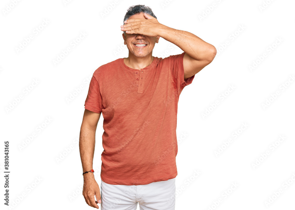 Handsome middle age man wearing casual clothes smiling and laughing with hand on face covering eyes for surprise. blind concept. Handsome middle age man wearing casual clothes smiling and laughing with hand on face covering eyes for surprise. blind concept.