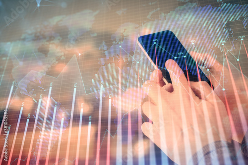 Double exposure of man's hands holding and using a digital device and forex graph drawing. Financial market concept.