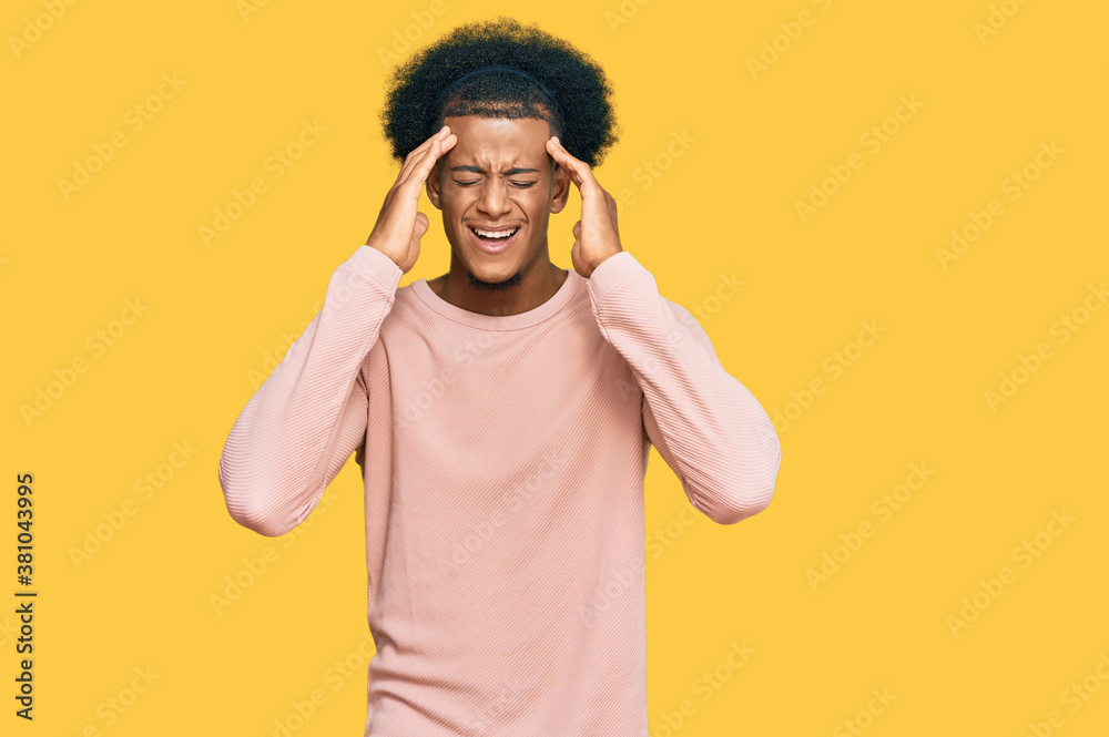 African american man with afro hair wearing casual clothes with hand on head for pain in head because stress. suffering migraine. African american man with afro hair wearing casual clothes with hand on head for pain in head because stress. suffering migraine.