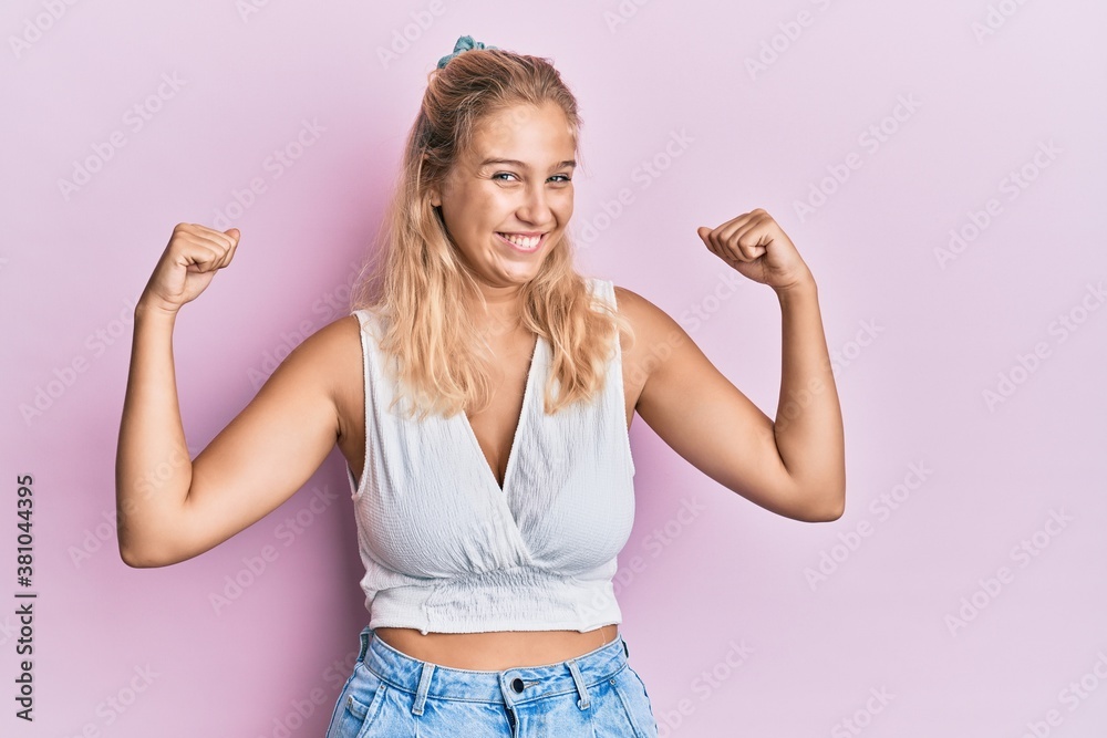 Obraz premium Young blonde girl wearing casual clothes showing arms muscles smiling proud. fitness concept.