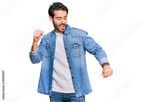 Young hispanic man wearing casual clothes dancing happy and cheerful, smiling moving casual and confident listening to music