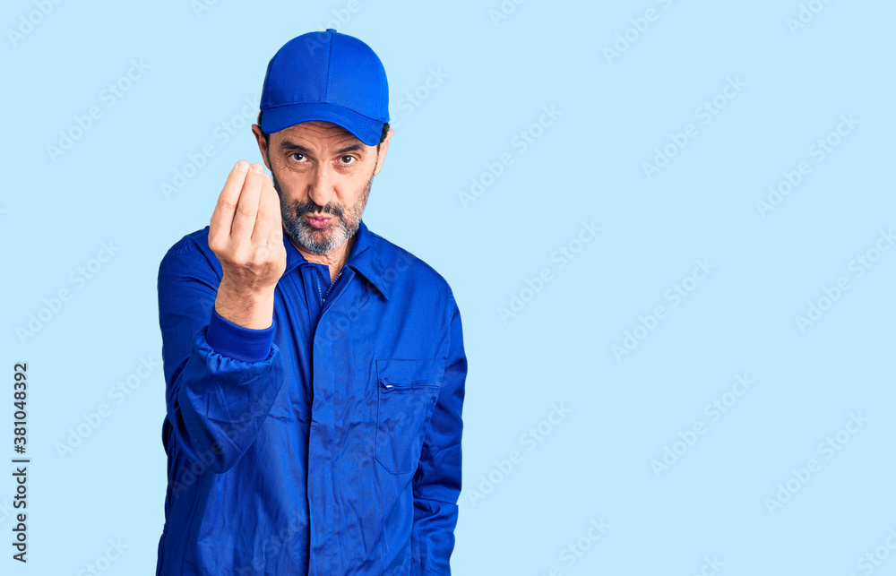 Middle age handsome man wearing mechanic uniform doing italian gesture with hand and fingers confident expression