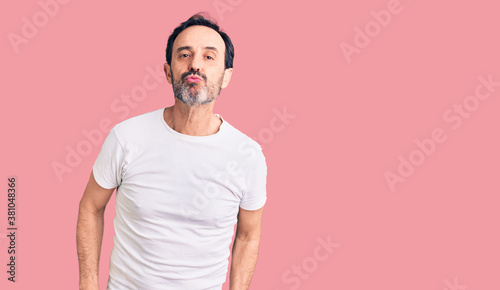 Middle age handsome man wearing casual t-shirt looking at the camera blowing a kiss on air being lovely and sexy. love expression. © Krakenimages.com