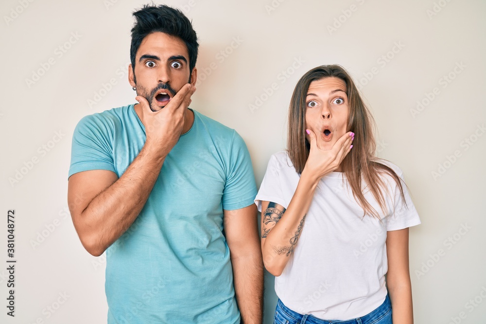 Beautiful young couple of boyfriend and girlfriend together looking fascinated with disbelief, surprise and amazed expression with hands on chin Beautiful young couple of boyfriend and girlfriend together looking fascinated with disbelief, surprise and amazed expression with hands on chin
