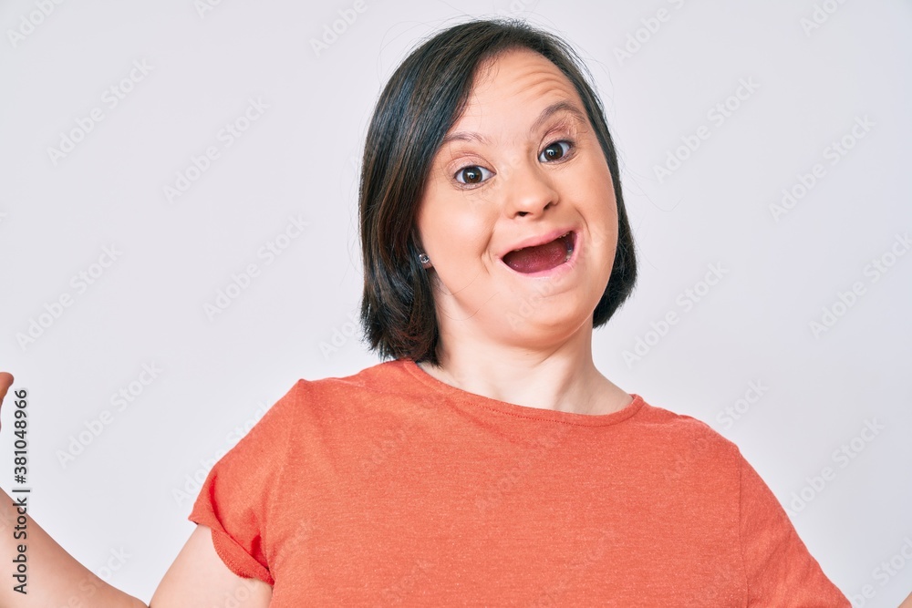Brunette woman with down syndrome wearing casual clothes celebrating victory with happy smile and winner expression with raised hands Brunette woman with down syndrome wearing casual clothes celebrating victory with happy smile and winner expression with raised hands