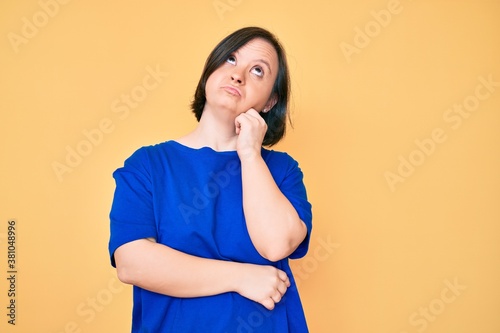 Brunette woman with down syndrome wearing casual clothes thinking concentrated about doubt with finger on chin and looking up wondering © Krakenimages.com
