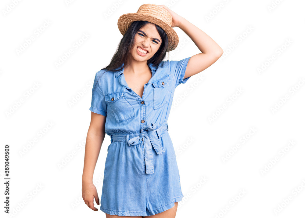 Brunette teenager girl wearing summer hat confuse and wonder about question. uncertain with doubt, thinking with hand on head. pensive concept. Brunette teenager girl wearing summer hat confuse and wonder about question. uncertain with doubt, thinking with hand on head. pensive concept.