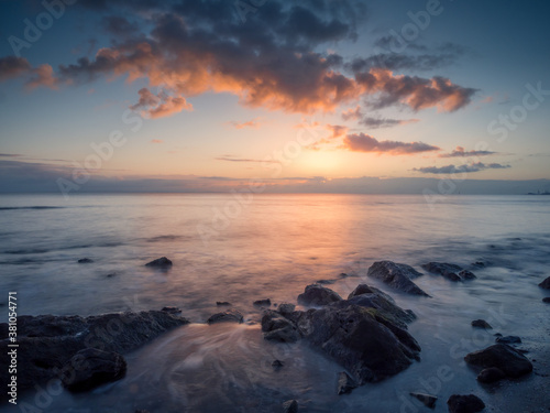 Beautiful Seaside Sunrise with Reflections and Rocks