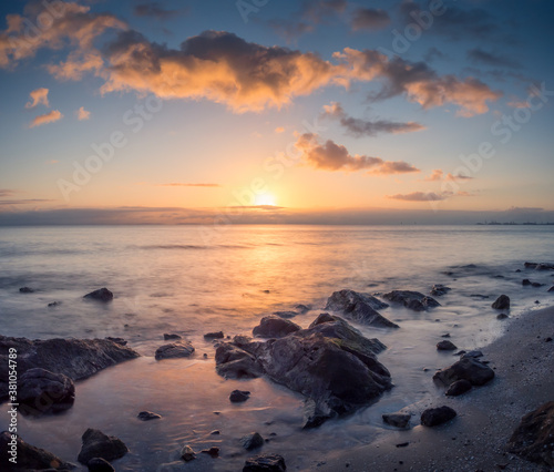 Beautiful Seaside Sunrise with Reflections and Rocks