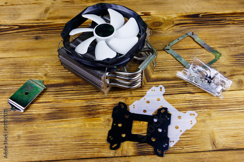 Modern CPU cooler with installation kit on a wooden desk photo