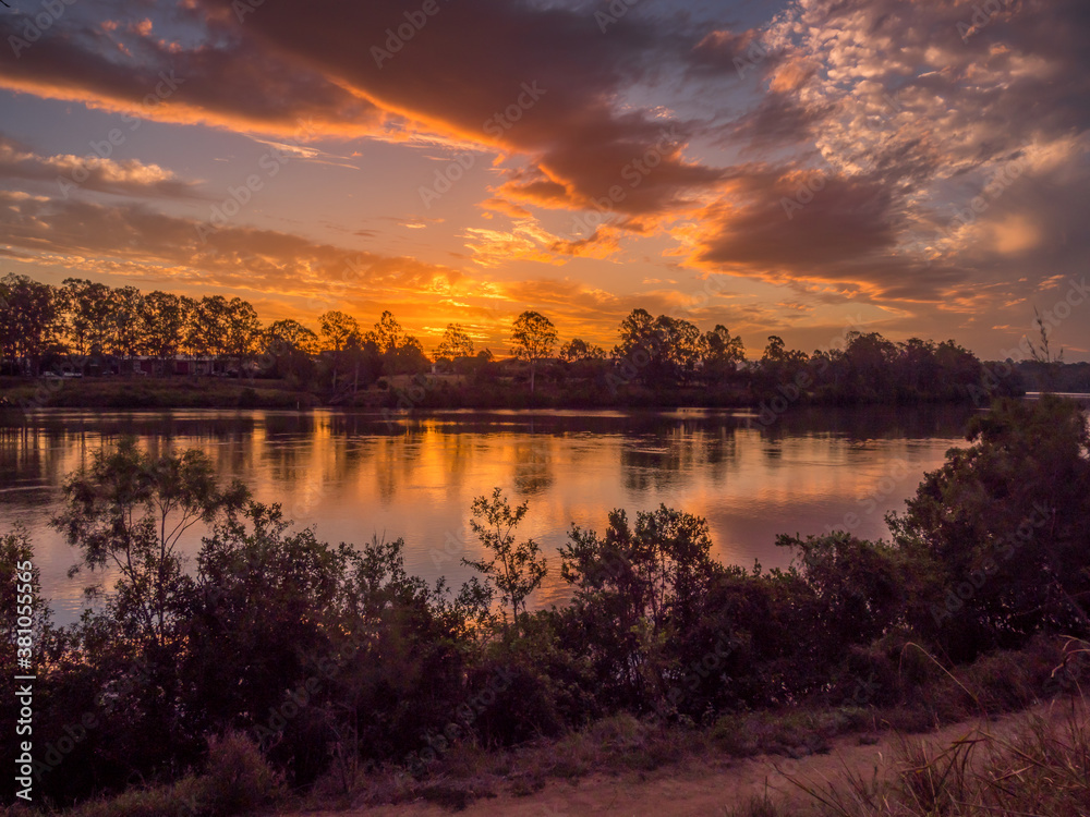 Obraz premium Beautiful Riverside Sunset with Reflections